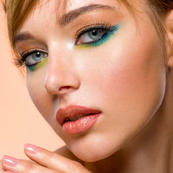 Face of an young girl close-up with a green color makeup. Stylish makeup. Beautiful girl with trandy makeup. Face of an young girl close-up with a green color makeup. Stylish makeup.